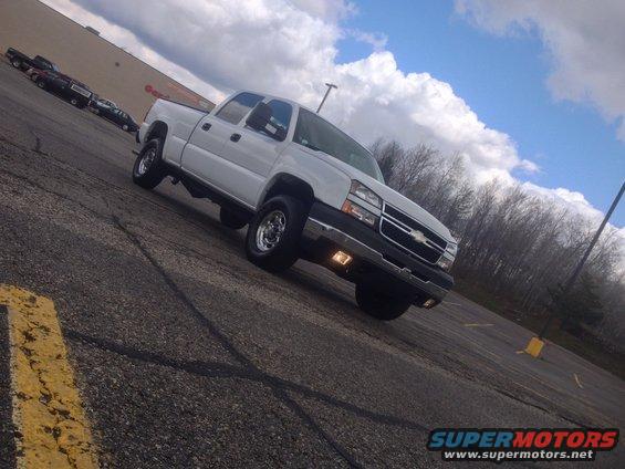 White Chevrolet Silverado pickup truck, front 3/4 view, parked on asphalt
