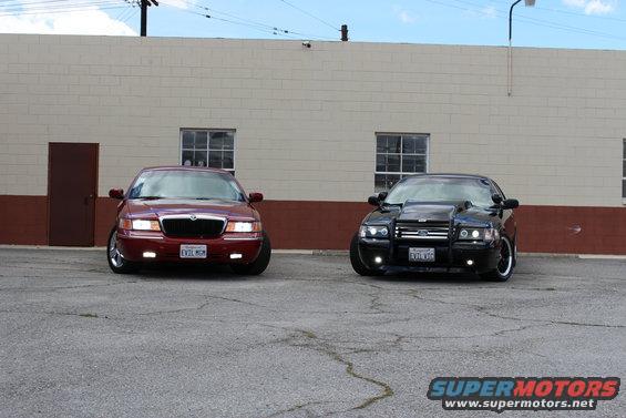 Red 2002 Mercury Grand Marquis and black modified sedan parked front-out