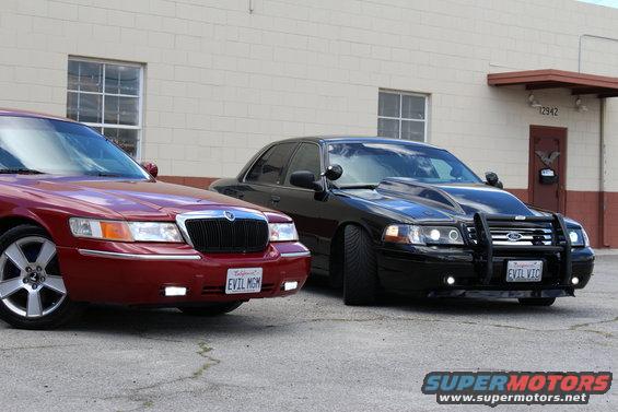 Red Mercury Grand Marquis and black modified Mercury Grand Marquis parked outside
