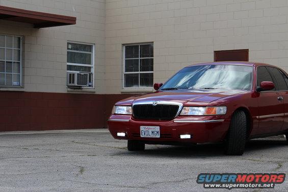 2002 Mercury Grand Marquis, red, parked in front of a brick building