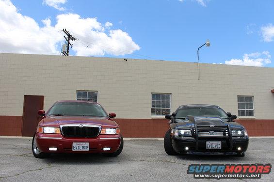 Red sedan with 'EVIL MGM' plate next to black sedan with 'EVIL VIC' plate