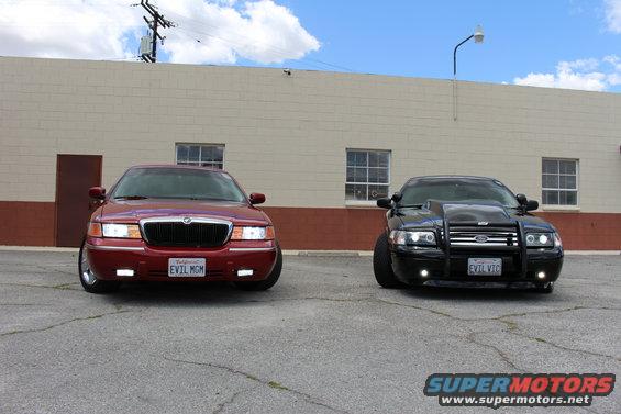 Red 2002 Mercury Grand Marquis and black Ford sedan parked front view