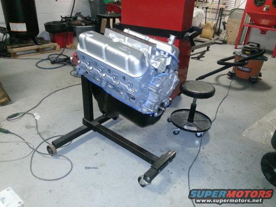 Silver engine on a black stand in a garage