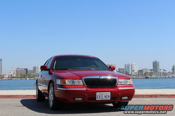 Red 2002 Mercury Grand Marquis parked by the water