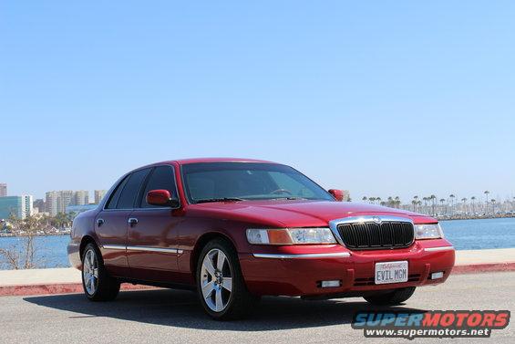 Red 2002 Mercury Grand Marquis parked by the water, front three-quarter view