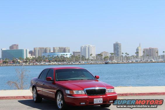 Red 2002 Mercury Grand Marquis parked by the water
