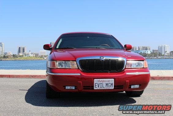 Red 2002 Mercury Grand Marquis parked by the water, front view
