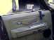 1987 Ford Crown Victoria LTD - Close-up of a car's interior door panel, showing the armrest, door handle, and window controls.