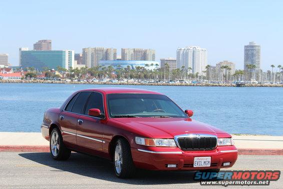 Red 2002 Mercury Grand Marquis parked by the water