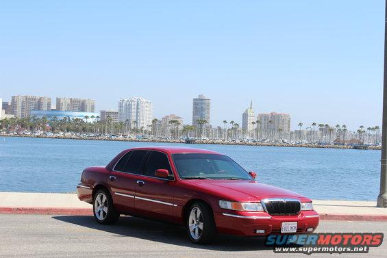 Red 2002 Mercury Grand Marquis parked by the water