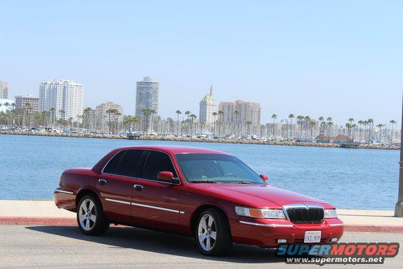 Red 2002 Mercury Grand Marquis parked by the water, front 3/4 view