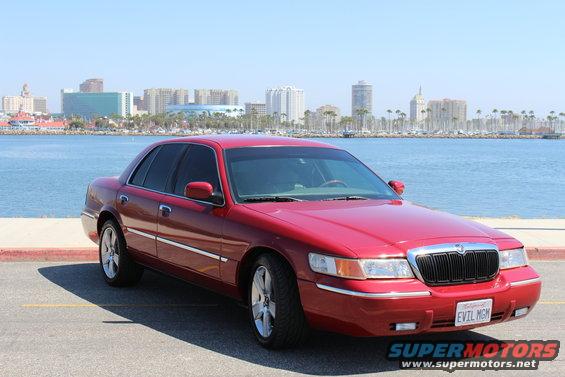 Red 2002 Mercury Grand Marquis parked by the water