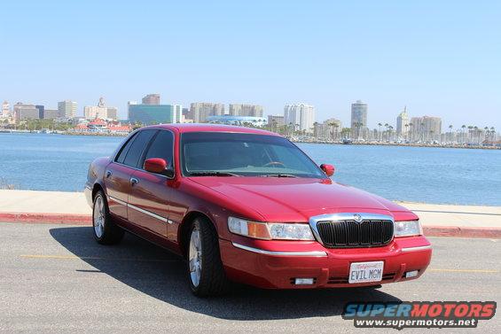 Red 2002 Mercury Grand Marquis parked by the water