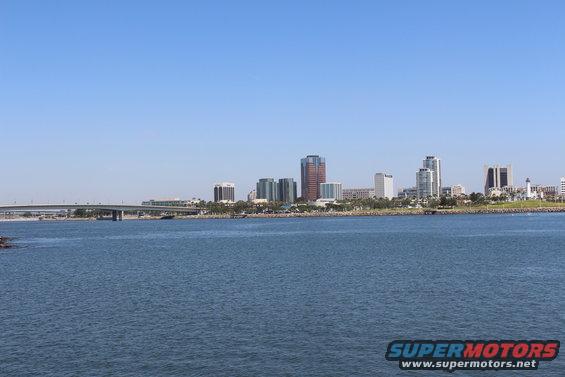 Waterfront view of a city skyline with a bridge in the distance