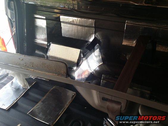 Vehicle interior rear area with soundproofing material applied to panels