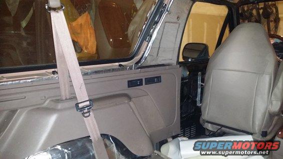 Tan interior of a 1992 Ford Bronco with removed door panel and exposed soundproofing