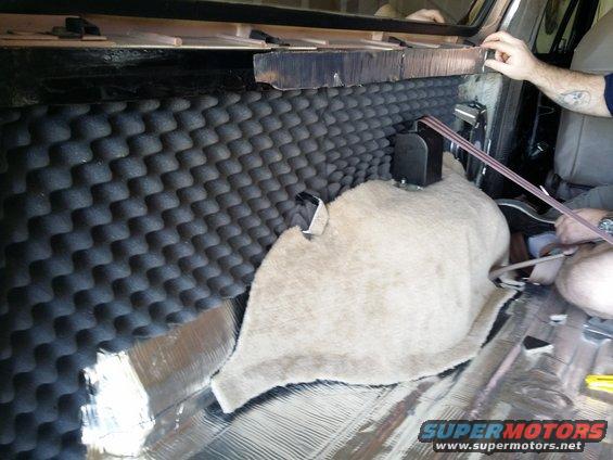 Vehicle interior with soundproofing foam and insulation being installed on the rear panel and floor