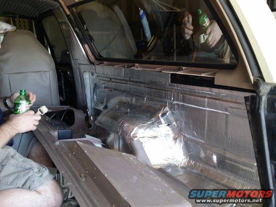 Interior of vehicle with soundproofing material being applied to the door panel