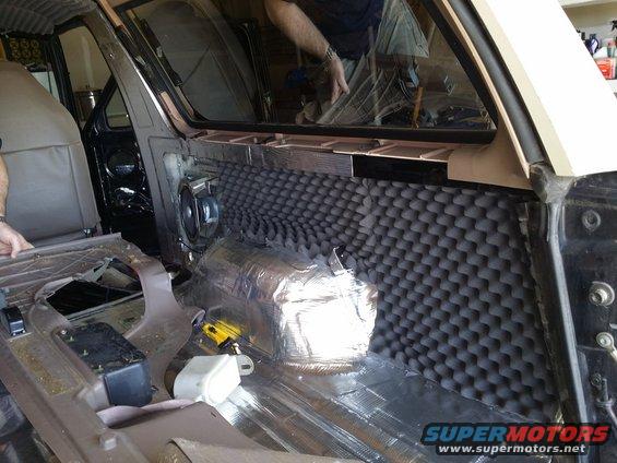 1994 Ford Bronco interior with soundproofing material on door and floor panels, speaker visible