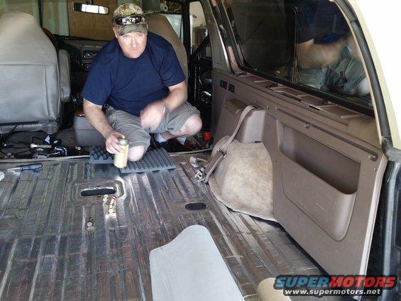 Interior of a 1994 Ford Bronco with soundproofing material being applied to the floor