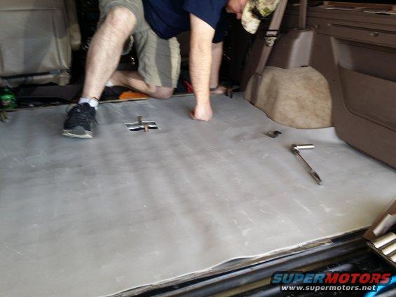Vehicle interior with soundproofing material laid on the floor, tools nearby