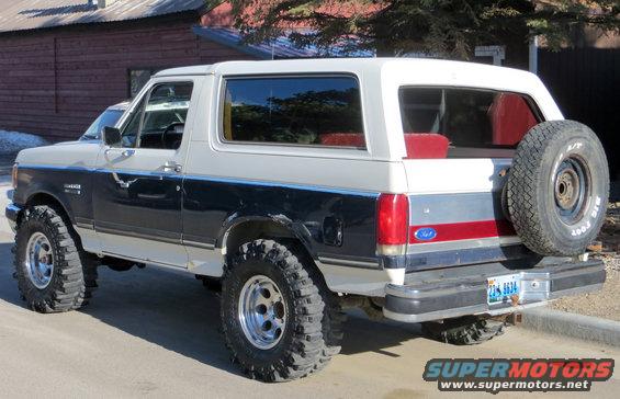 1989 Ford Bronco, rear 3/4 view, two-tone white and blue with spare tire