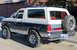 1989 Ford Bronco - This 1989 Ford Bronco is shown from the rear 3/4 angle, a two-tone paint scheme and a spare tire mounted on the tailgate.
