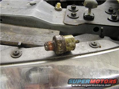Oil pressure sensor removed from engine bay, showing threads and electrical connector