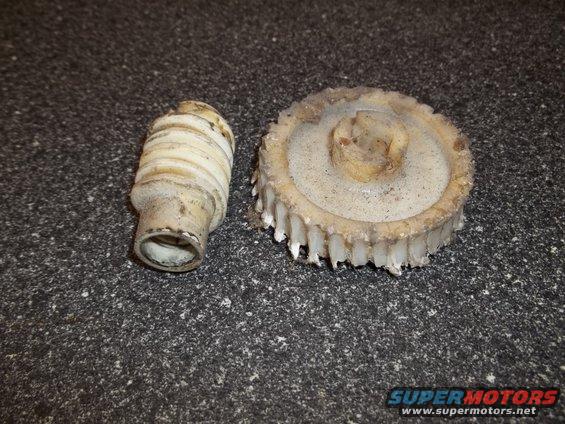 Plastic gear and a ribbed shaft, likely from a car's interior mechanism