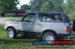 Gray 1989 Ford Bronco parked on grass, house in background