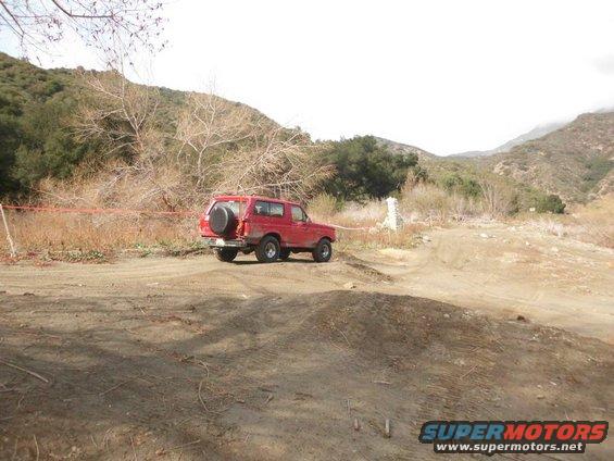 1988 Ford Bronco parked on dirt road with spare tire on rear door