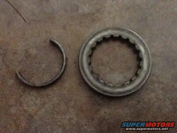Metal ring with internal splines and a C-clip on a textured surface
