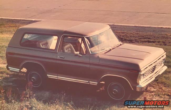 Brown 1978 Ford Bronco parked on grassy area, viewed from front-right