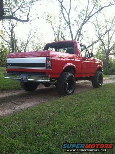 Red 1992 Ford Bronco, 3/4 front view, lifted with large tires