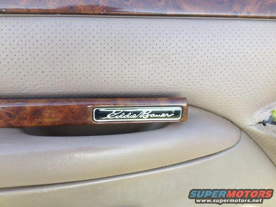 Eddie Bauer emblem on wood-grain trim inside a vehicle door panel