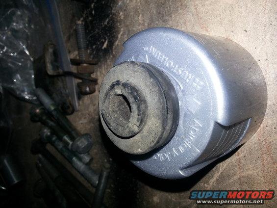 Silver part with black rubber bushing, text reads 'RUST-OLEUM' and 'APPLICATOR JOLT'. Bolts are visible to the left
