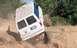 1990 Ford Bronco - This modified van is attempting an off-road course, with one side lifted high off the ground.