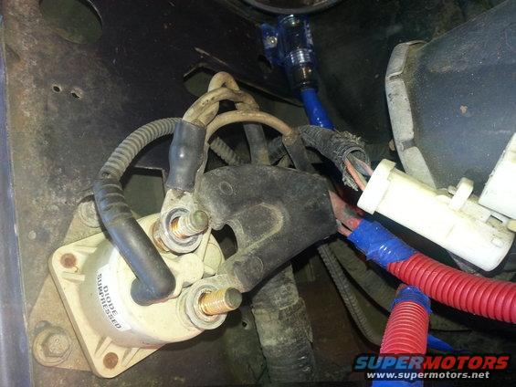 Close-up of starter motor wiring with blue and red taped connections
