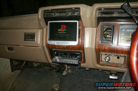 Dashboard with a screen showing PlayStation logo, car stereo below, and speedometer