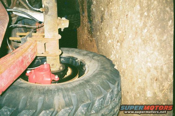 Rear disc brake assembly with red caliper and large tire