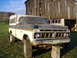 2007 Ford F-150 - This vintage Ford F-150 pickup truck, equipped with a camper shell, is parked outdoors near a weathered wooden barn.