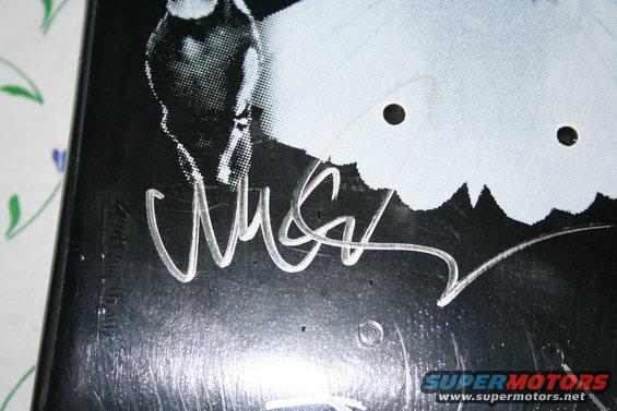 Black document with a white graphic and a silver signature, Supermotors.net logo visible