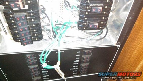 Boat electrical panel with many circuit breakers and green wires