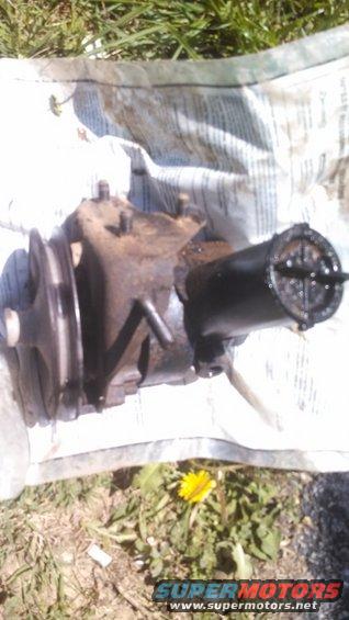 power steering pump with pulley, sitting on newspaper outdoors