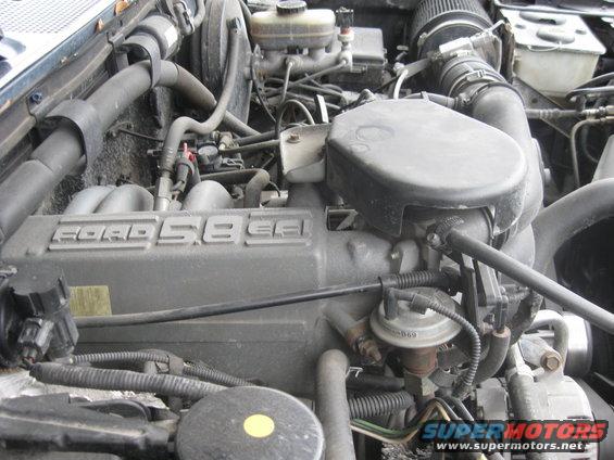 Ford 5.8L engine with air intake and brake fluid reservoir visible
