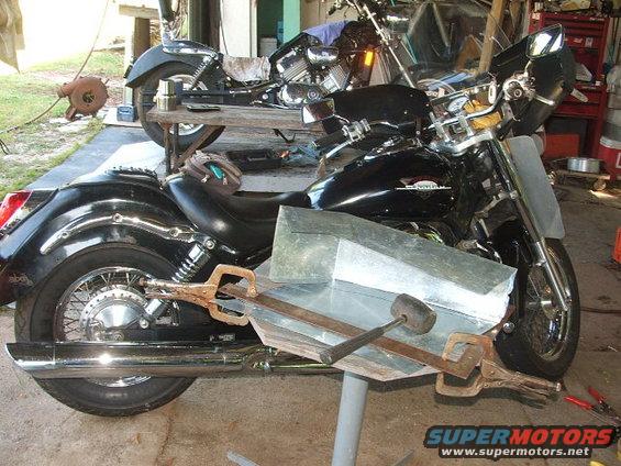 Black motorcycle with metal fabrication clamps attached to its side