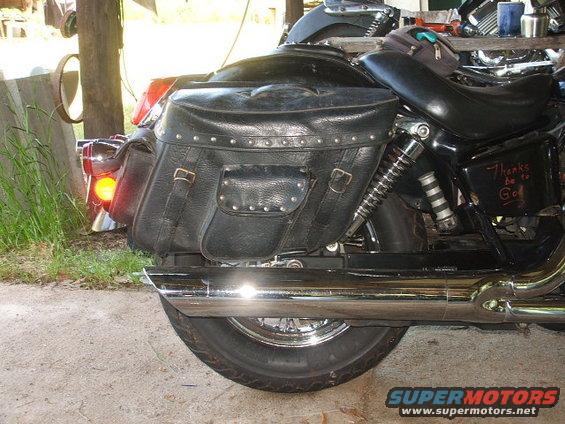 Motorcycle with black studded saddlebags, chrome exhaust, and a red taillight