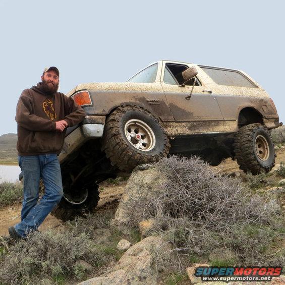 1989 Ford Bronco on rocks, covered in mud