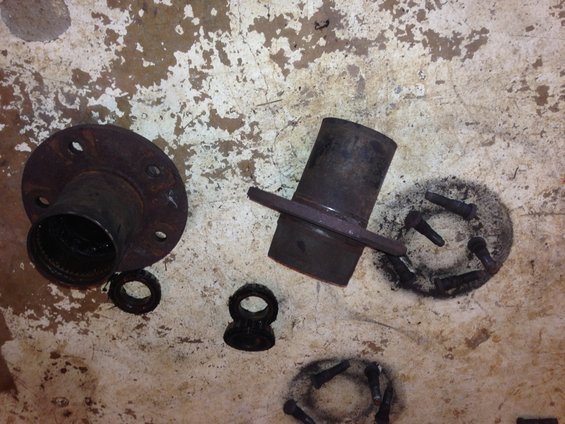 Rusty brake rotor and hub assembly parts on a concrete floor