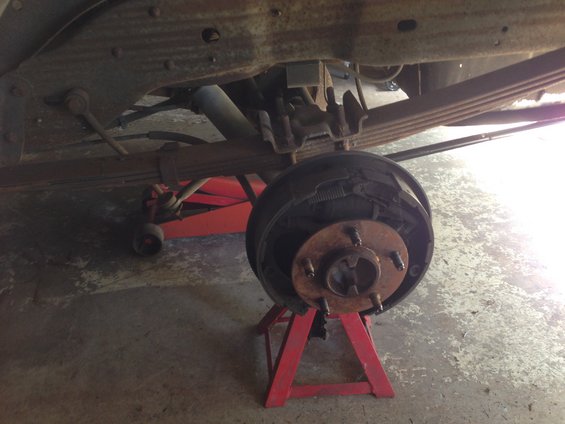 Rear drum brake assembly on a vehicle, supported by a jack stand